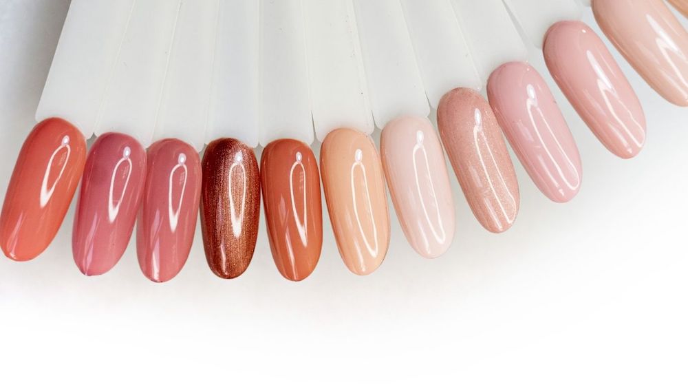 Swatches of different gel nail colours in pink and peach tones