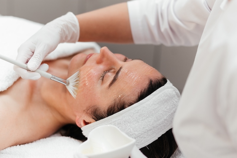 Aesthetician performing a facial treatment on a client in a beauty salon