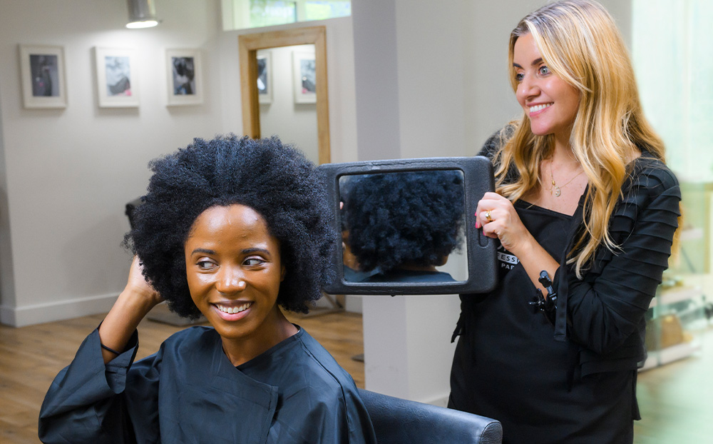 Hairdresser revealing the back of the hairstyle to a client in the hair salon