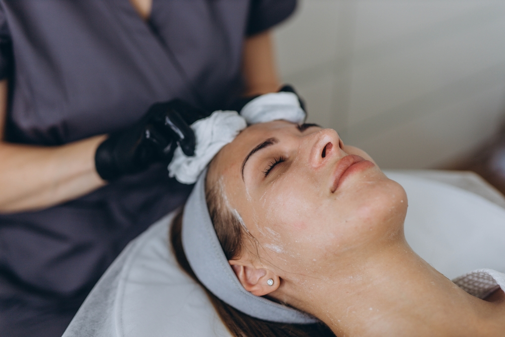 aesthetic practitioner applying chemical peel skin treatment to woman
