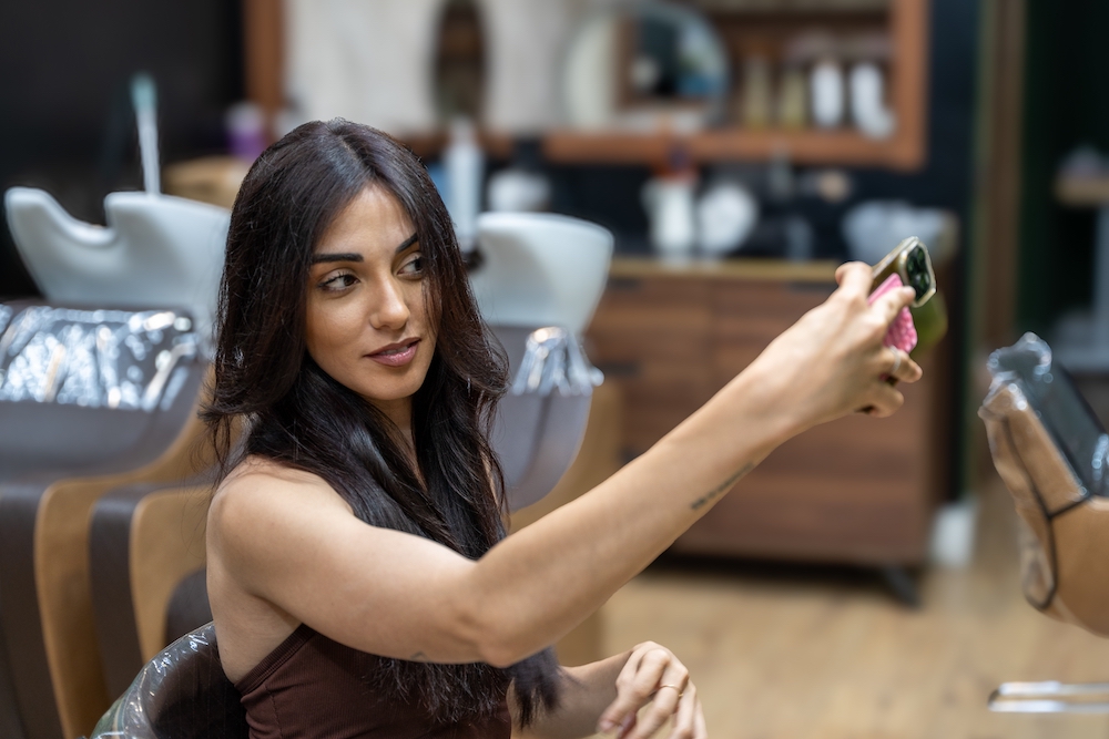 Influencer takin a picture of her hair in hair salon