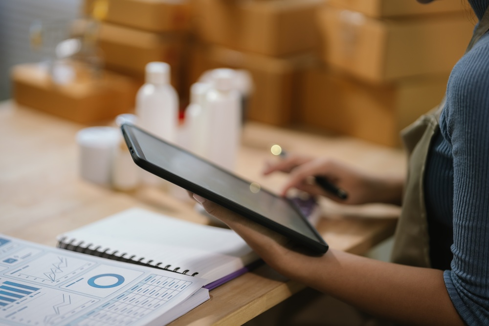 Aesthetic clinic professional using a tablet to manage skincare products and online retail orders